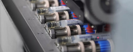 Vaccine vials on a piece of machinery. 