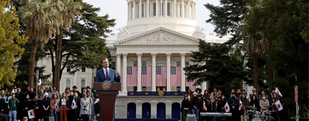 Gov. Gavin Newsom speaking at a lectern outside the California Capitol in Sacramento