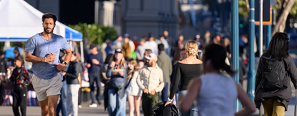 A young man jogs in a semi-crowded area near the Ferry Building in San Francisco.