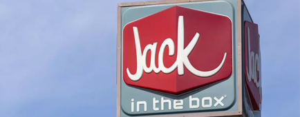 A Jack in the Box sign against a blue sky. A Jack in the Box sign against a blue sky.