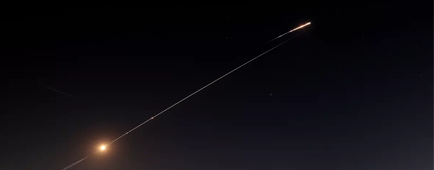Rocket trails are seen in a nighttime sky
