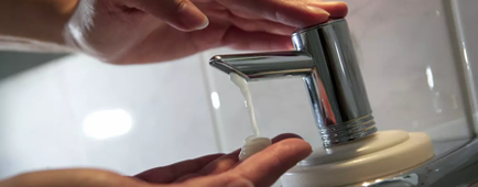 A person washes their hands under a faucet. A person washes their hands under a faucet.