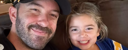 A man and a young girl in football jerseys smile for the camera. A man and a young girl in football jerseys smile for the camera.