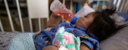 A young girl with a bandage on her left arm.