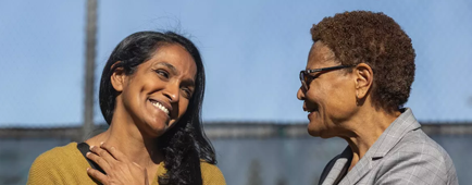 Los Angeles City Councilmember Nithya Raman, left, talking with Mayor Karen Bass