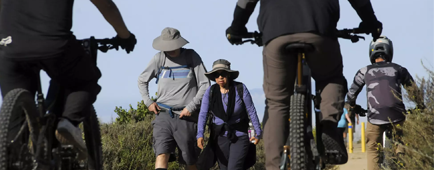 Hikers are passed by a group of pedal-assist mountain bikers inside Aliso and Wood Canyons Wilderness Park in Aliso Viejo.