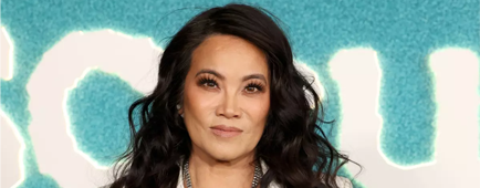 Dr. Sandra Lee standing in a double-breasted cream suit with one hand on her hip 