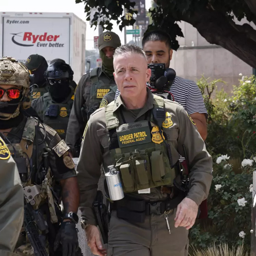 U.S. Border Patrol Sector Chief Gregory Bovino marches with federal agents outdoors