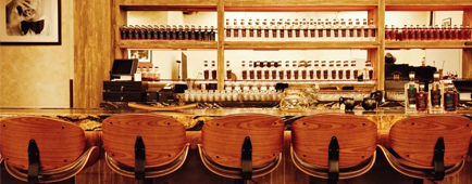 The backs of wooden bar stools lined up along the bar at Hollywood Distillery The backs of wooden bar stools lined up along the bar at Hollywood Distillery