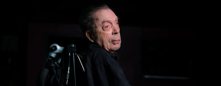 Tim Curry in his wheelchair poses for a side-profile portrait.