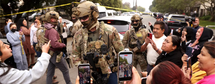 a border patrol and other federal agents are surrounded by a crowd with cellphones recording a border patrol and other federal agents are surrounded by a crowd with cellphones recording