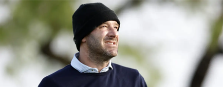 Tony Romo wears a ski cap while playing golf